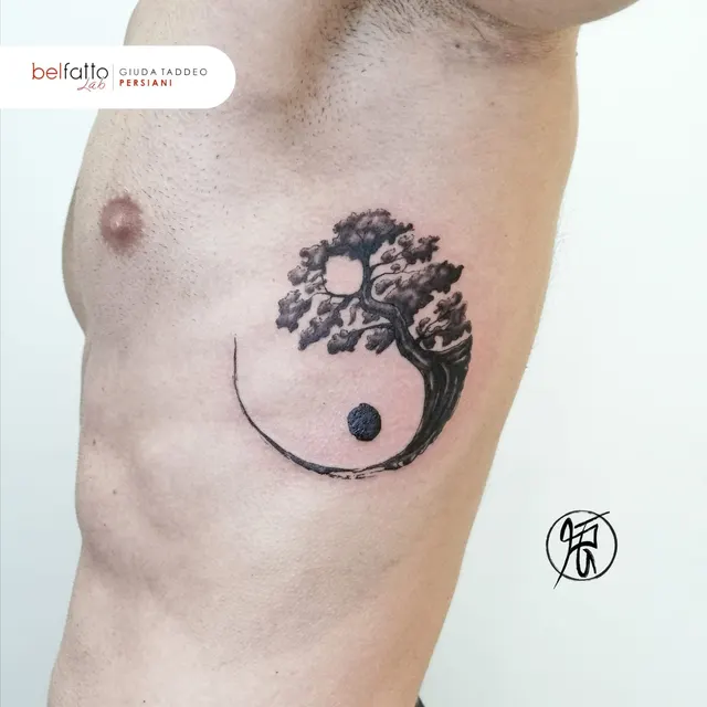 Tatuaggio yin e yang con albero sul fianco